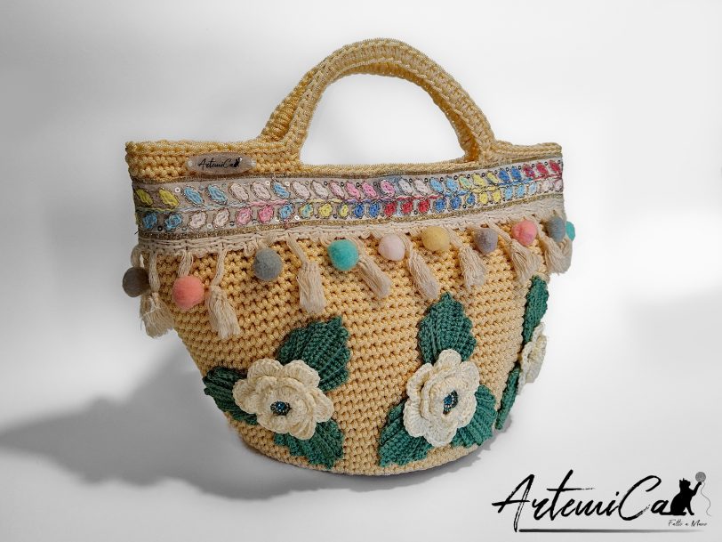 1 (Artemicat) Coffa Sole di Sicilia: Borsa Fatta a Mano all’Uncinetto in cordino Beige con Pompon colorati e Rose - Colori Vibranti e Anima Mediterranea